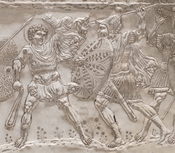 David is depicted holding a slingshot and Goliath is holding a spear as if he is about to throw the spear at David.