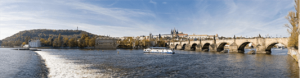 A photograph of the Charles Bridge that leads up to the Prague Castle with the Vltava River flowing beneath the bridge.