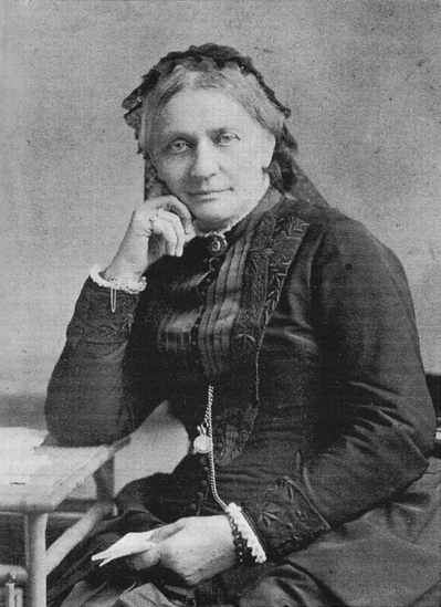 An old black and white photograph depicting a woman seated at a table, exuding a sense of nostalgia and timelessness.