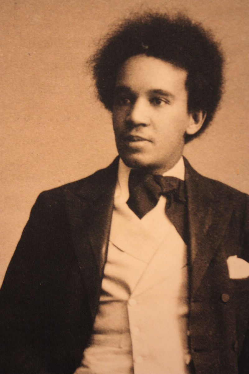 An old photograph depicting a man with a prominent afro hairstyle, showcasing vintage fashion and style.