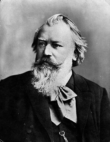 A black and white portrait of a bearded man, showcasing his facial features and expression in a classic style.