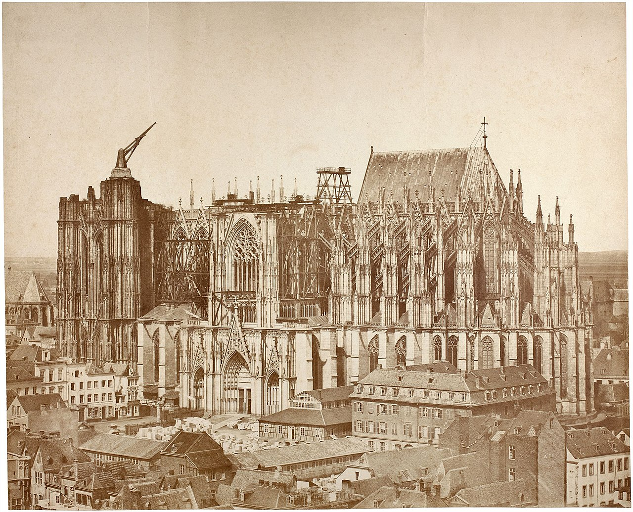 An old photograph depicting a cathedral featuring a prominent tower, showcasing historical architectural details.