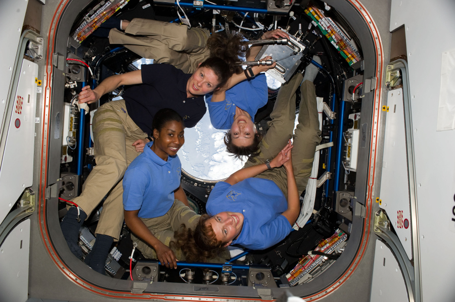 Photograph of four astronauts in free fall.