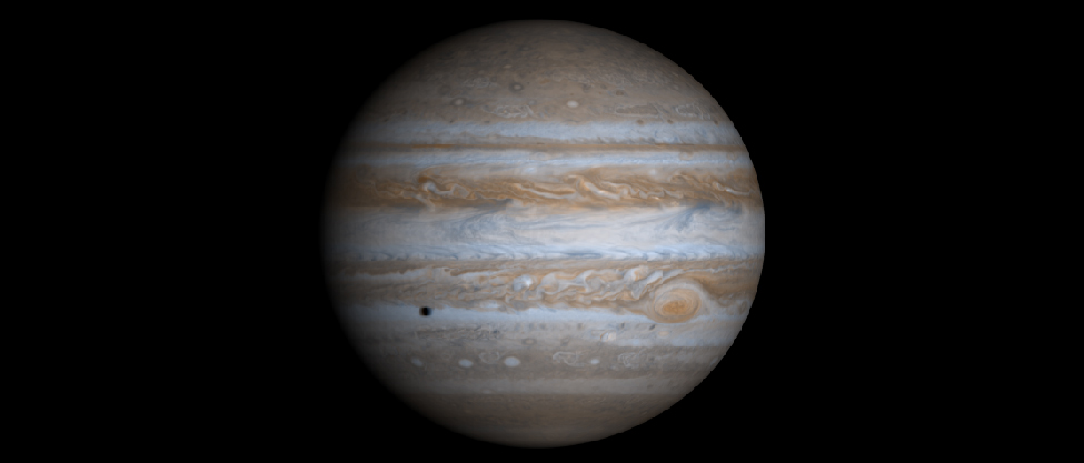 Image of Jupiter taken by the Cassini spacecraft. The alternating light and dark cloud bands are clearly seen, as is the Great Red Spot. At lower left, below the equator, the shadow of one of Jupiter’s moons is projected onto the cloud tops.